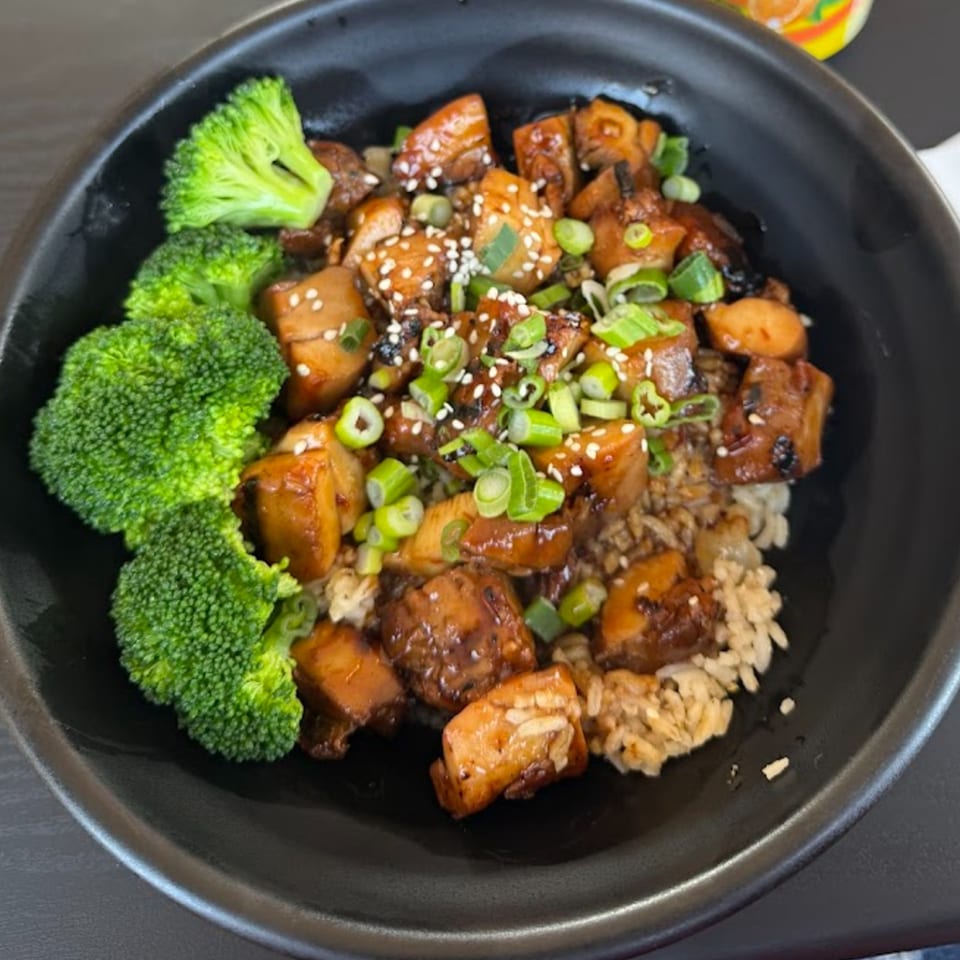 Roll N Wok's teriyaki chicken and rice bowl with broccoli, sesame seeds, and green onions.